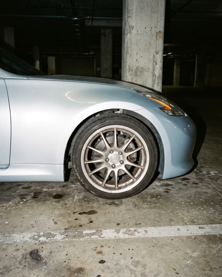 A silver sports car in an underground car park at night