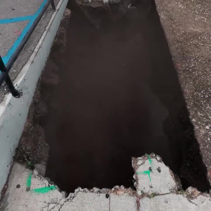 Le trottoir ouvert sur un trou sombre, le pochoir sur le bord