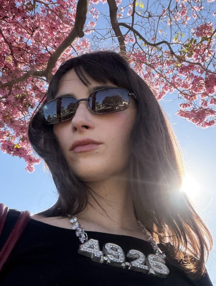 Un membre du casting sous des cerisiers en fleurs, le collier 4.9.26 au cou