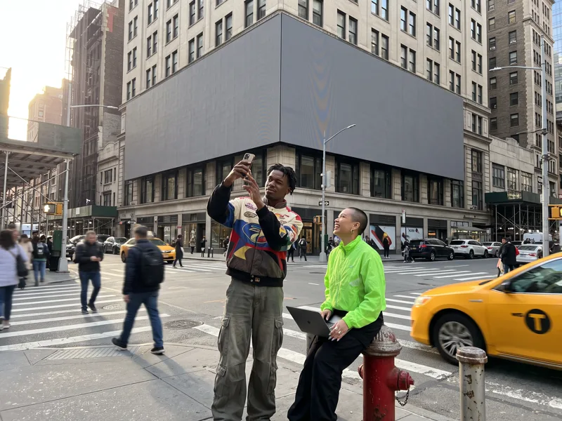 The team photographs a corner billboard from the exact viewing spot