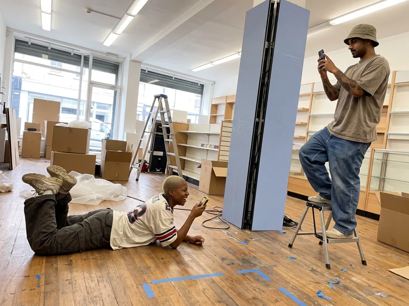 Two members of the team measure the distance to an LED column in a concept store